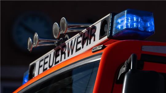 Ein Einsatzfahrzeug der Feuerwehr mit eingeschaltetem Blaulicht.