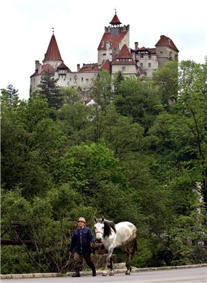 Ein Einwohner des rumänischen Ortes Bran führt sein Pferd am Schloss Bran vorbei. Bran Castle aus dem 14. Jahrhundert war in zahlreichen Hollywood-Dracula-Filmen zu sehen.