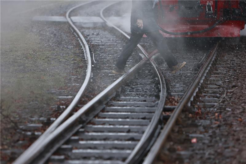 Ein Fahrgast geht über ein Gleisstück am Bahnhof Gernrode. Foto: picture alliance/dpa | Matthias Bein