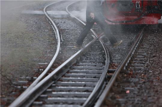 Ein Fahrgast geht über ein Gleisstück am Bahnhof Gernrode. Foto: picture alliance/dpa | Matthias Bein