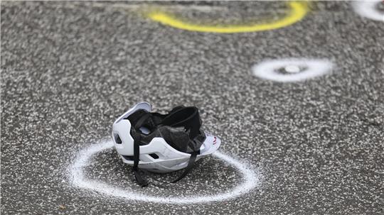 Ein  Fahrradhelm liegt auf der Straße an einer Unfallstelle.