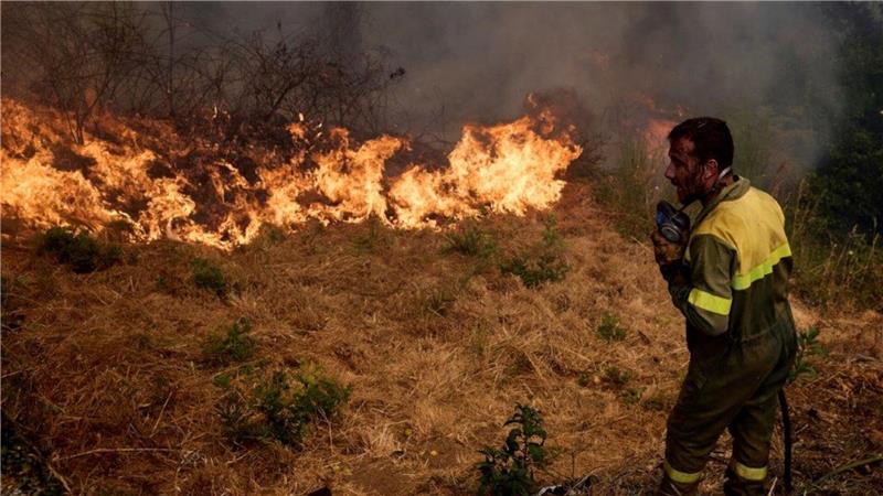 Ein Feuerwehrmann bekämpft ein Feuer, das sich auf das Dorf Rebordondo in der Nähe von Ourense im Nordwesten Spaniens ausbreitet.