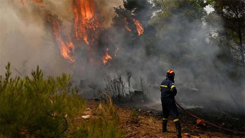 Ein Feuerwehrmann bereitet sich bei einem Waldbrand nordwestlich von Athen darauf vor, die Flammen zu löschen.