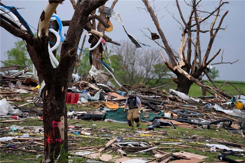 Tote und Schäden nach Tornados in den USA Ein Feuerwehrmann geht in Greenfield, Iowa, zwischen von einem Tornado zerstörten Häusern umher.