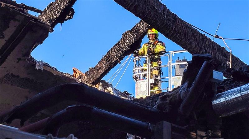 Flammen in Klinik - zwei Tote in Ludwigslust Ein Feuerwehrmann untersucht von einer Drehleiter aus den ausgebrannten Dachstuhl. (Handoutbild)