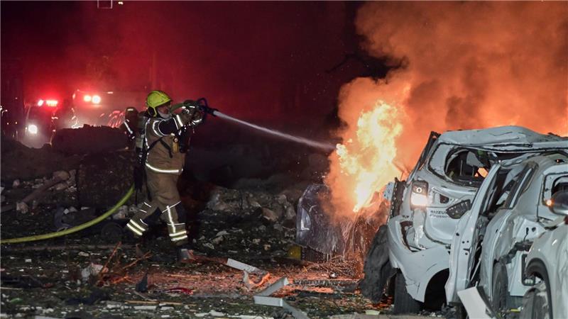 Ein Feuerwehrmann versucht, ein brennendes Auto zu löschen.