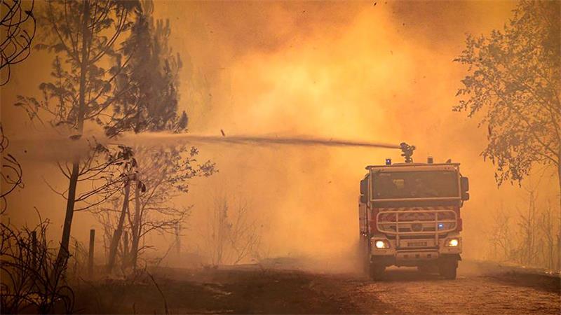 Ein Feuerwehrwagen sprüht Flüssigkeit auf einen Waldbrand in der Region Bordeaux. (Archivbild)