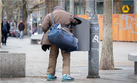Ein Flaschensammler greift in eine Mülltonne. Foto: Kay Nietfeld | pa/dpa