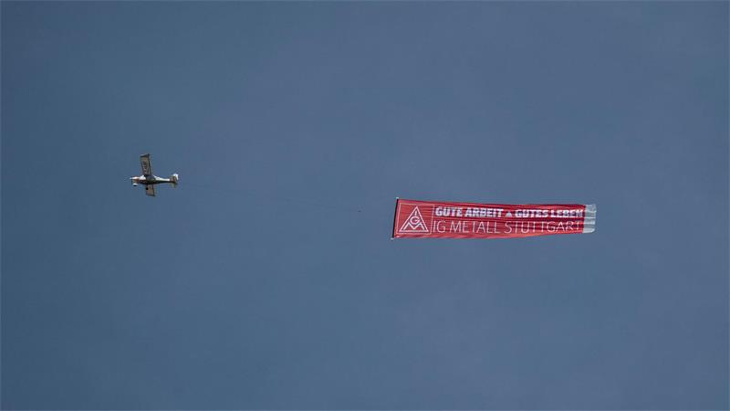 IG Metall mobilisiert rund 175.000 Auto-Beschäftigte Ein Flugzeug mit einem IG-Metall-Banner fliegt über das Porsche-Stammwerk in Zuffenhausen.