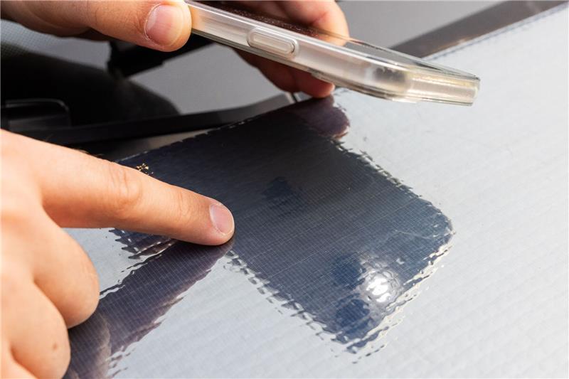 Fraunhofer entwickelt Folie mit Solarzellen für Autos Ein Forscher des Fraunhofer ISE zeigt auf die Struktur der Solarzellen auf einer Motorhaube.