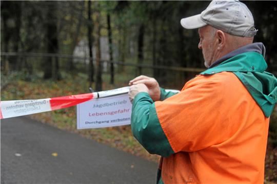 Ein Forstwirt bringt das Warnschild für die Jagd an.  Foto: Eggers
