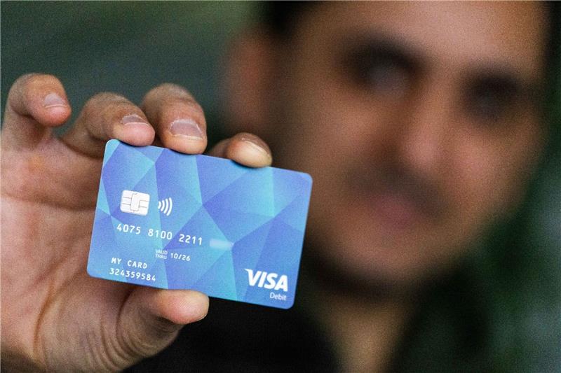 Bundesweite Bezahlkarte für Flüchtlinge kommt Ein Geflüchteter mit einer Debitcard.
