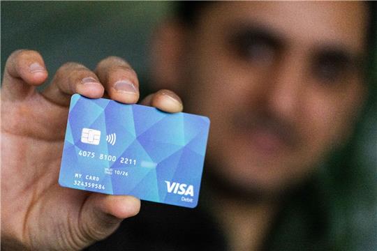 Ein Geflüchteter mit einer Debitcard.