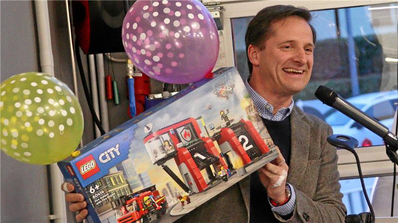 Ein Mann hält Lego-Bausatz in der Hand.