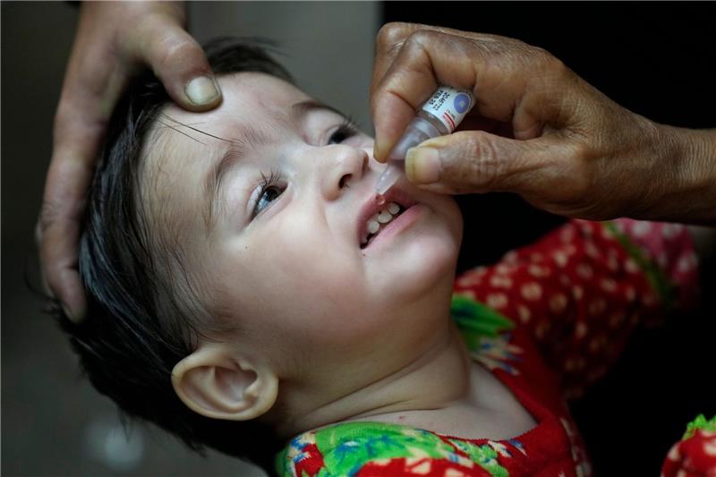 Ein Gesundheitshelfer verabreicht einem Kind einen Polio-Impfstoff.