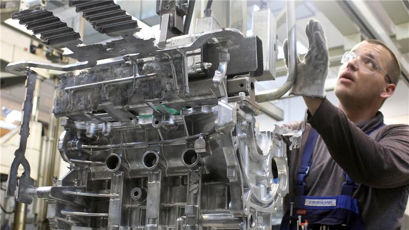 Ein Gießer arbeitet an einem Motorblock.