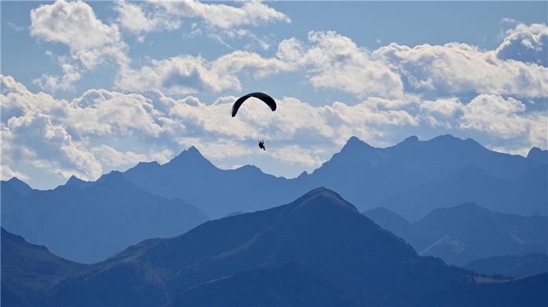 Ein Gleitschirmflieger dreht seine Runden über den bayerischen Voralpen im Tegernseer Tal.