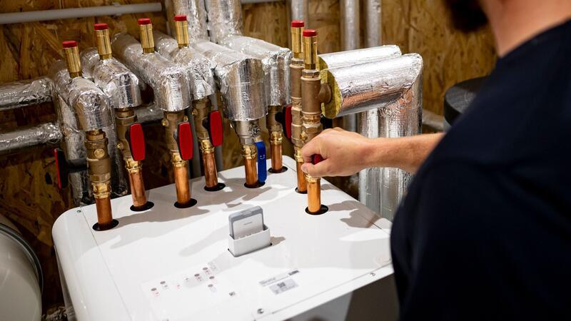 Ein Handwerker arbeitet an einer Wärmepumpe in der Enpal Akademie.