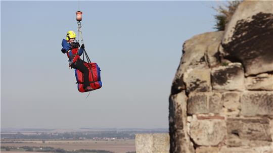 Ein Helfer der Bergwacht wird aus einem Hubschrauber der Polizei Sachsen-Anhalt am Regenstein in Blankenburg mit einer Seilwinde herabgelassen. Die Luftrettung ist im Harz ein wichtiger Baustein bei der Bergung Verletzter im unwegsamen Gelände.