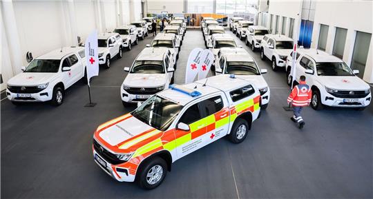 Ein Helfer vom Deutschen Roten Kreuz DRK steht bei der Übergabe von 22 Geländewagen von Volkswagen Nutzfahrzeuge.