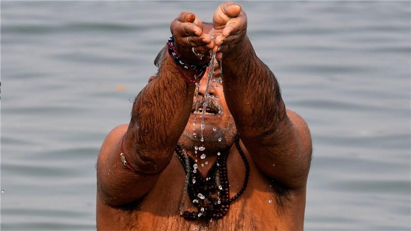Ein Hindu-Pilger verehrt den Sonnengott während eines rituellen Bades im Hooghly-Fluss anlässlich des Makar Sankranti-Festes in Kolkata.