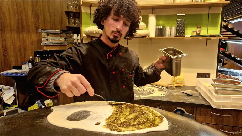 Ein Hingucker im Laden ist der Saj-Ofen. Auf der Metallkuppel backt Abdulrahman Almoallem dünne Brote und belegt sie.