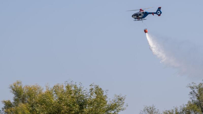 Feuerwehren üben Einsatz mit Hubschrauber Ein Hubschrauber der Polizei wirft bei einer Übung zur Waldbrandbekämpfung Löschwasser ab.