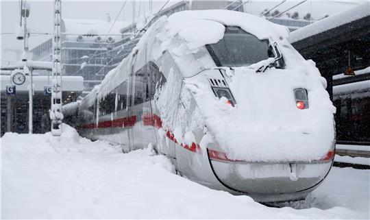 Ein ICE steht auf einem verschneiten Gleis am Münchner Hauptbahnhof.