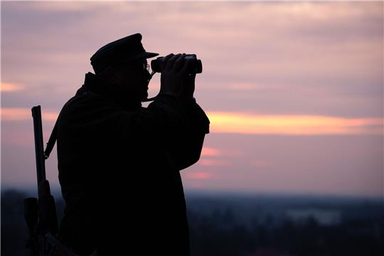 Ein Jäger blickt durch sein Fernglas in der Abenddämmerung. In Nordrhein-Westfalen startet die Messe Jagd & Hund.