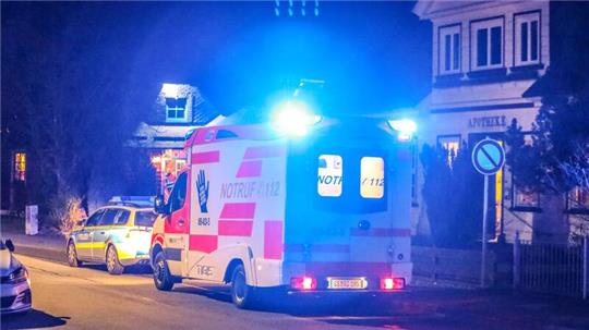 Ein Kranken- und ein Streifenwagen stehen am Straßenrand hintereinander.