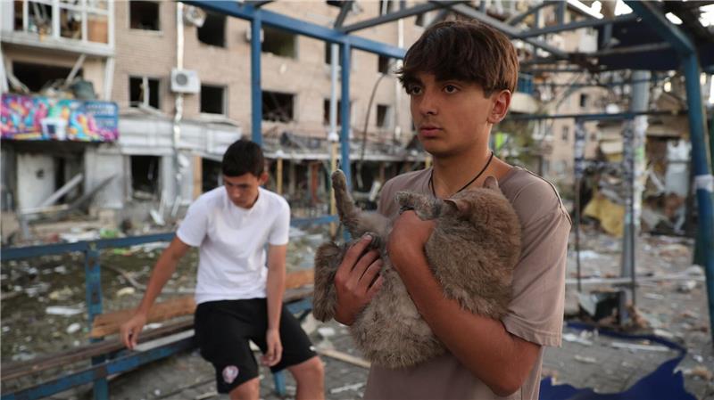 Ein Junge bringt nach einem russischen Luftangriff im ukranischen Saporischschja eine Katze in Sicherheit. 