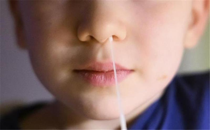Ein Junge führt für zum Corona-Selbsttest ein Stäbchen zum Abstrich in seine Nase ein. Mit Beginn des neuen Schuljahrs muss er das nicht täglich tun. Foto: Stratenschulte/dpa