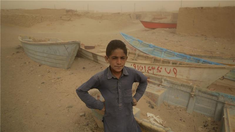 Iran: Staatsmedium warnt vor „nationaler Katastrophe“ Ein Junge im Iran steht vor alten Booten, wo einst ein See war.