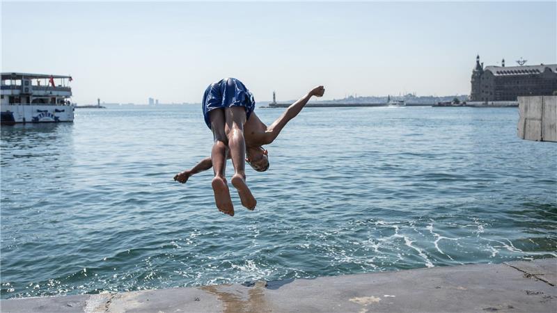 Ein Junge in Istanbul springt ins Meer, um sich abzukühlen.