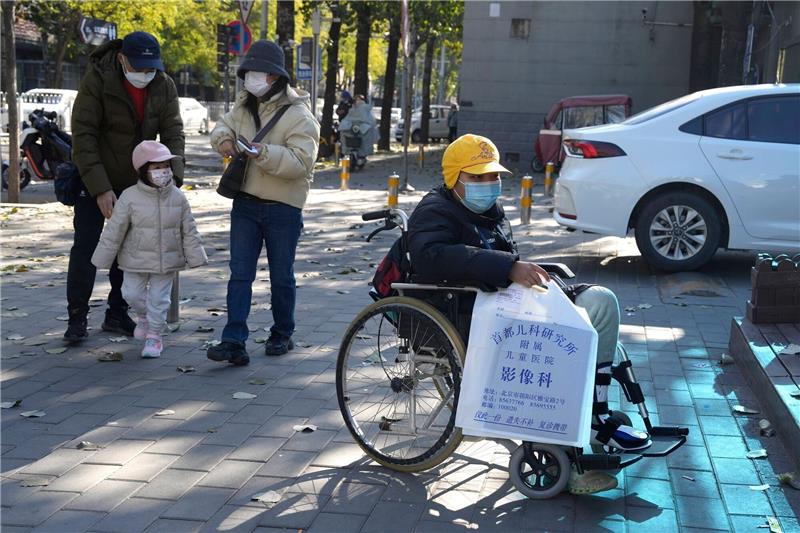 China ordnet mehr Vorbeugung wegen Atemwegsinfektionen an Ein Junge in einem Rollstuhl hält in Peking eine Tasche aus der radiologischen Abteilung eines Kinderkrankenhauses. In den vergangenen Tagen hatten Berichte über die starke Häufung von Atemwegserkrankungen bei Kindern Sorgen aufkommen lassen.