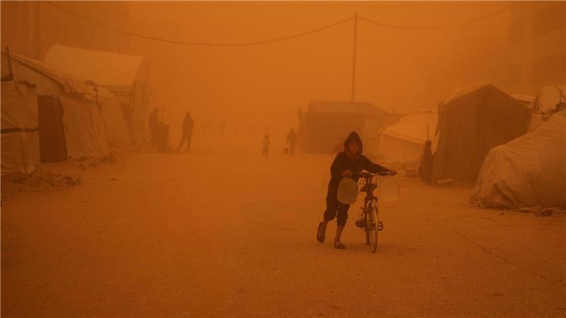Ein Junge schiebt sein Fahrrad durch einen Sandsturm in Chan Junis.