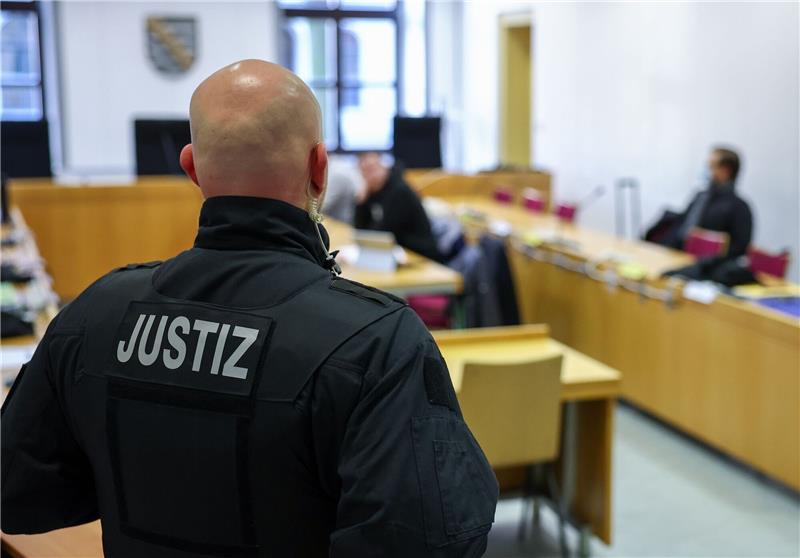 Jagd auf politische Gegner - Männer in Chemnitz vor Gericht Ein Justizbeamter steht vor Prozessbeginn vor einigen Angeklagten im Landgericht Chemnitz.