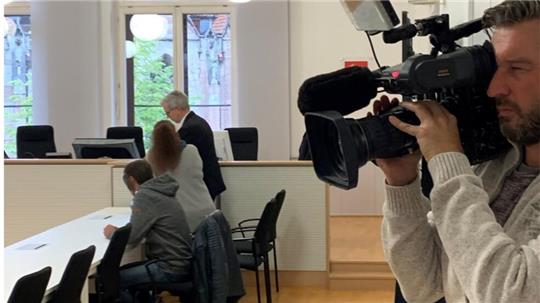 Ein Kameramann filmt am Donnerstag in den Gerichtssaal, in dem das Missbrauchsverfahren gegen ein Elternpaar aus Goslar läuft. Die 1. Strafkammer am Landgericht Braunschweig spricht die Angeklagten später von den Vorwürfen frei. Im Hintergrund sitzen die Eltern mit einem ihrer Anwälte.