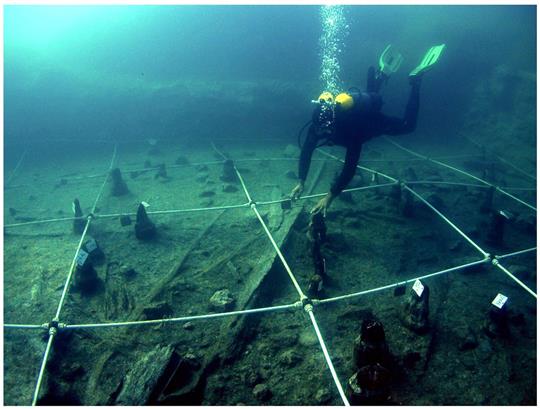 Ein Kanu wird Boden des Braccianosees ausgegraben. Die abgenutzten Überreste der mehr als 7000 Jahre alten Kanus lassen erahnen, wie ausgeprägt das Wissen über die Seefahrt bereits in der Jungsteinzeit war.