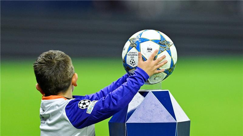 Ein Kind nimmt beim Einlauf der Mannschaften den Spielball in die Hände.