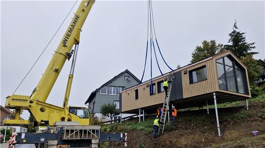 Ein Kran hebt das Tiny-Haus an den Hang in St. Andreasberg.