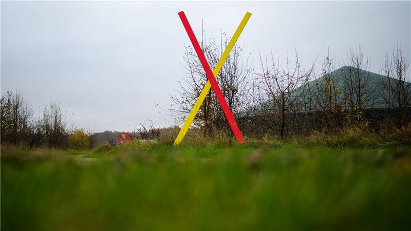 Ein Kreuz steht als Protest gegen eine geplante Neubaustrecke der Bahn an einem Hof. (Archivbild)