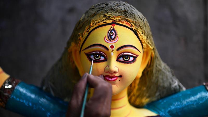 Ein Kunsthandwerker verleiht einer Tonfigur der hinduistischen Göttin Durga im Vorfeld eines ihr gewidmeten Festes in Dhaka den letzten Schliff.
