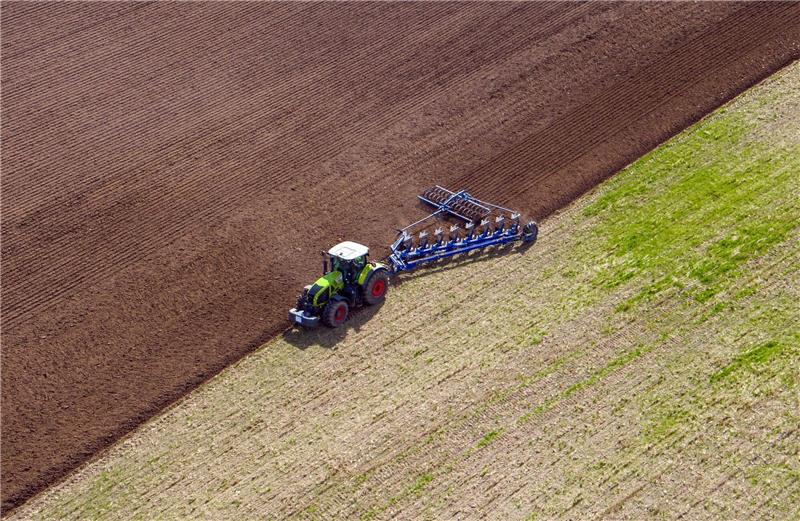 Ackerboden ist Boden des Jahres 2023 Ein Landwirt pflügt ein abgeerntetes Feld und bereitet es für die Neubestellung vor.