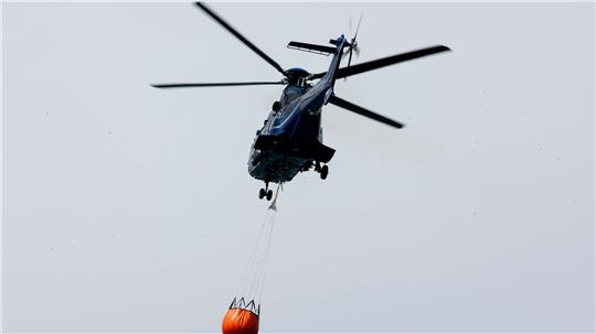 Ein Löschhubschrauber der Bundespolizei fliegt über dem Zeithainer Tagebau und nimmt Wasser auf, um den Waldbrand Gohrischheide zu bekämpfen.