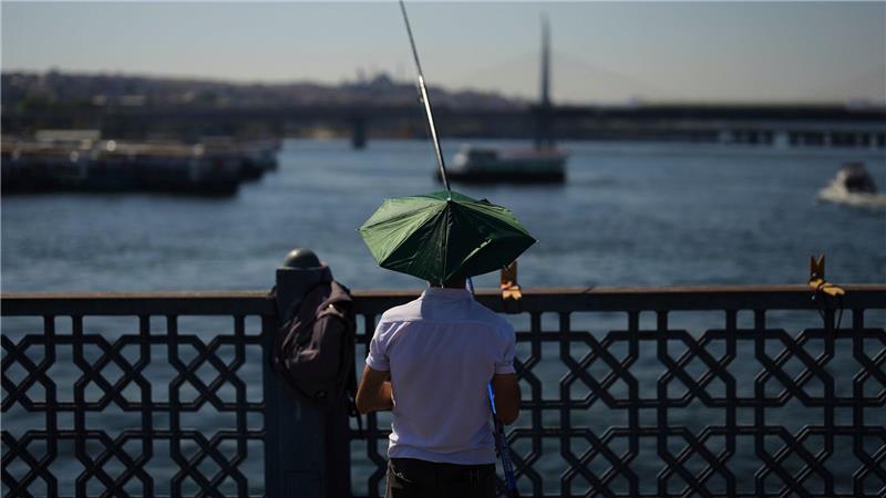 Bilder des Tages Ein Mann angelt an einem heißen Sommertag auf der Galata-Brücke in Istanbul.
