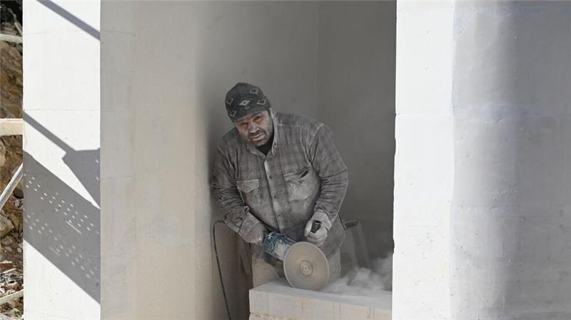 Feiern im Schutt - Das Leben nach dem Erdbeben in der Türkei Ein Mann arbeitet auf einer Baustelle in Antakya.