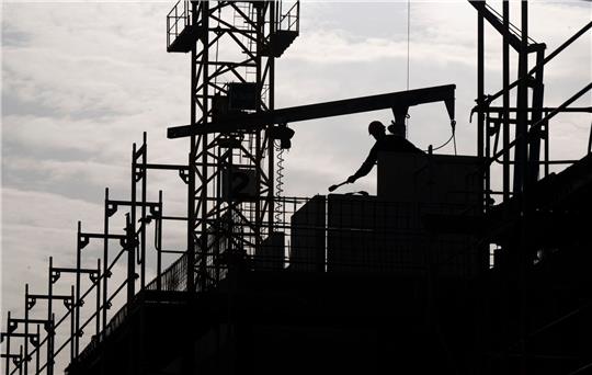 Ein Mann arbeitet auf einer Neubau-Baustelle: Die Bundesbank beurteilt die Konjunkturlage in Deutschland besser als noch vor einigen Wochen angenommen.