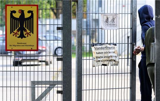 Ein Mann betritt neben einem Schild vom Bundesamt für Migration und Flüchtlinge die Landesaufnahmebehörde Niedersachsen am Standort Braunschweig.