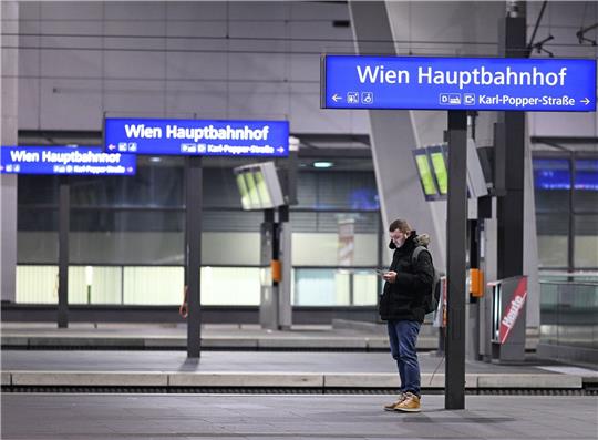 Ein Mann blick auf sein Smartphone an einem Bahnsteig im Hauptbahnhof Wien.